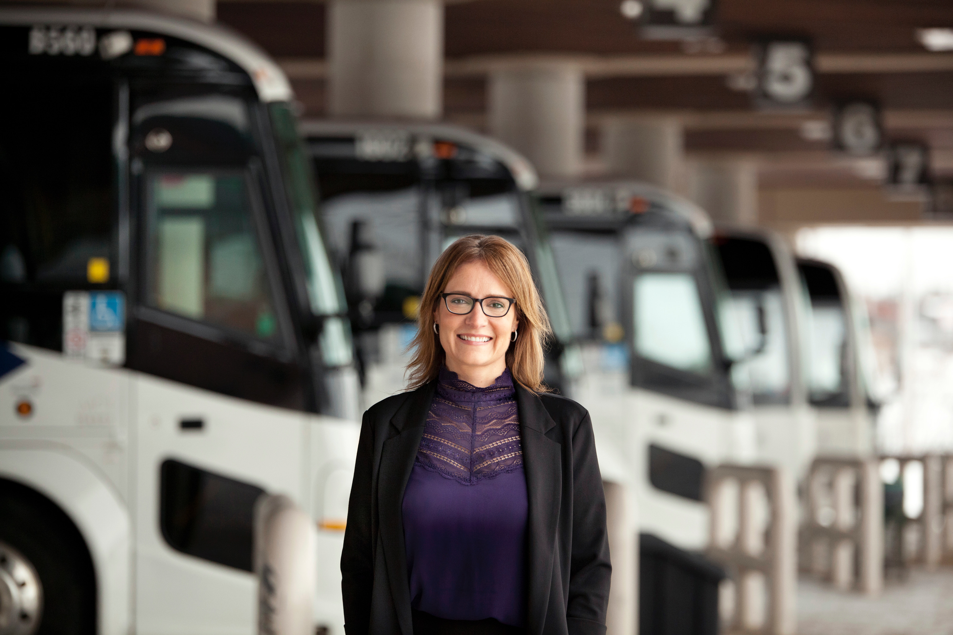 Corina Moore standing in front of a row of Ontario Northland motor coaches