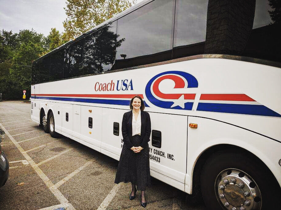 Linda Burtwistle standing beside a Coach USA motor coach