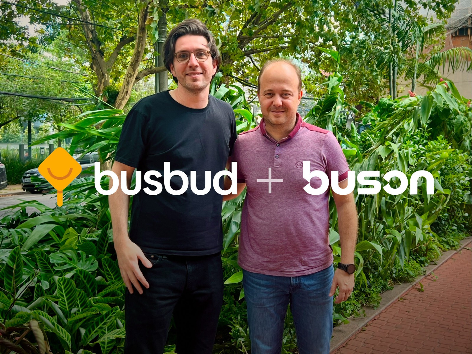 LP Maurice, CEO of Busbud, and Thiago Carvalho, CEO of Buson, posing together outdoors to mark the two companies joining forces